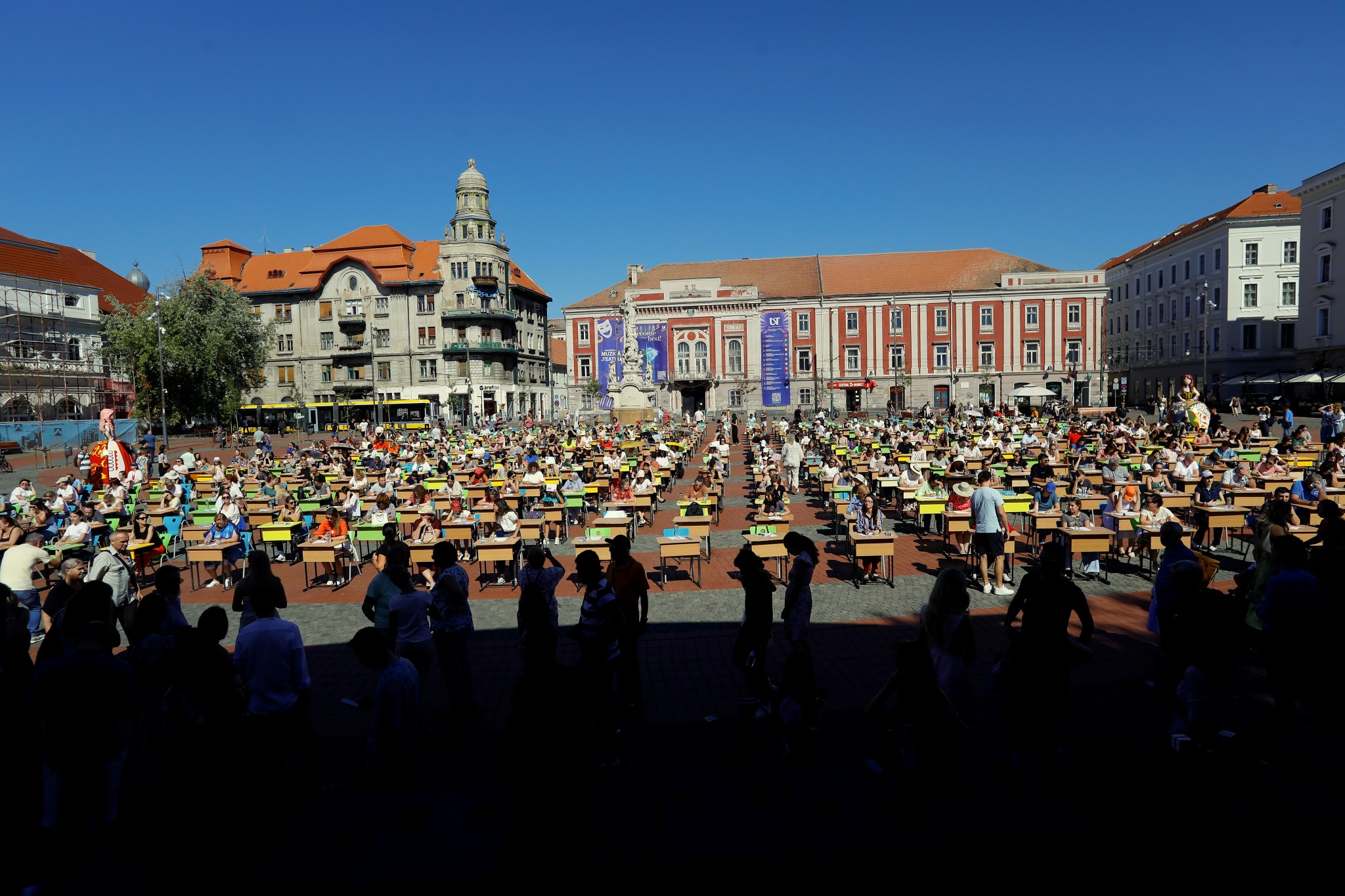 Persoane participa la evenimentul Marea Dictare Urbana, concurs cu premii pentru iubitorii de limba romana, cu varste intre 9 si 99 de ani, in Piata Libertatii din Timisoara